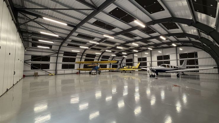 Classic biplane and light aircraft inside one of the closed hangars at Thruxton Airfield