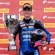 Bradley Ray holding a trophy and his helmet