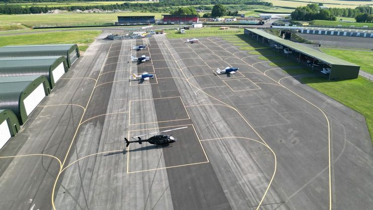 Aircraft parked on the apron at Thruxton Airfield, with the open bay hangar on the right