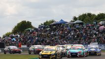 BTCC Cars racing at Thruxton with a full spectator bank in the background.