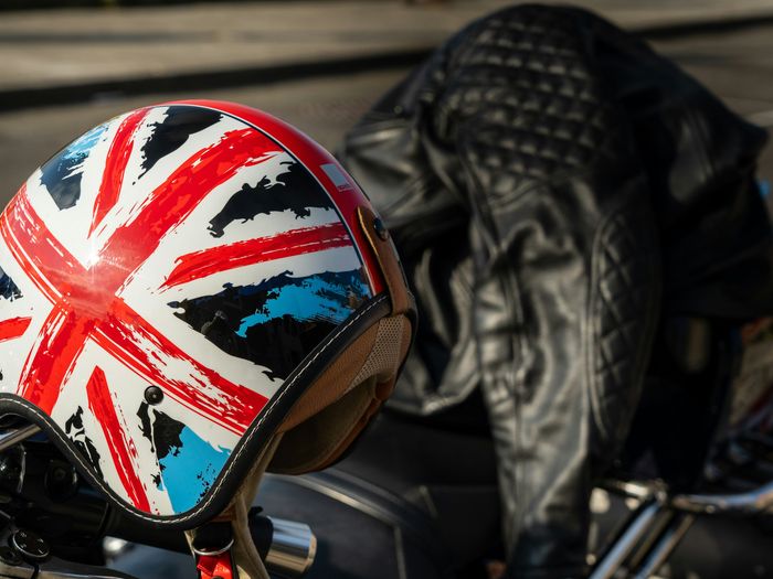 Union Jack covered bike helmet and motorcycle leathers on top of a motorcycle.