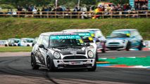MINI CHALLENGE Trophy racing at Thruxton. Cars going round the chicane with a full Woodham Hill in the background.